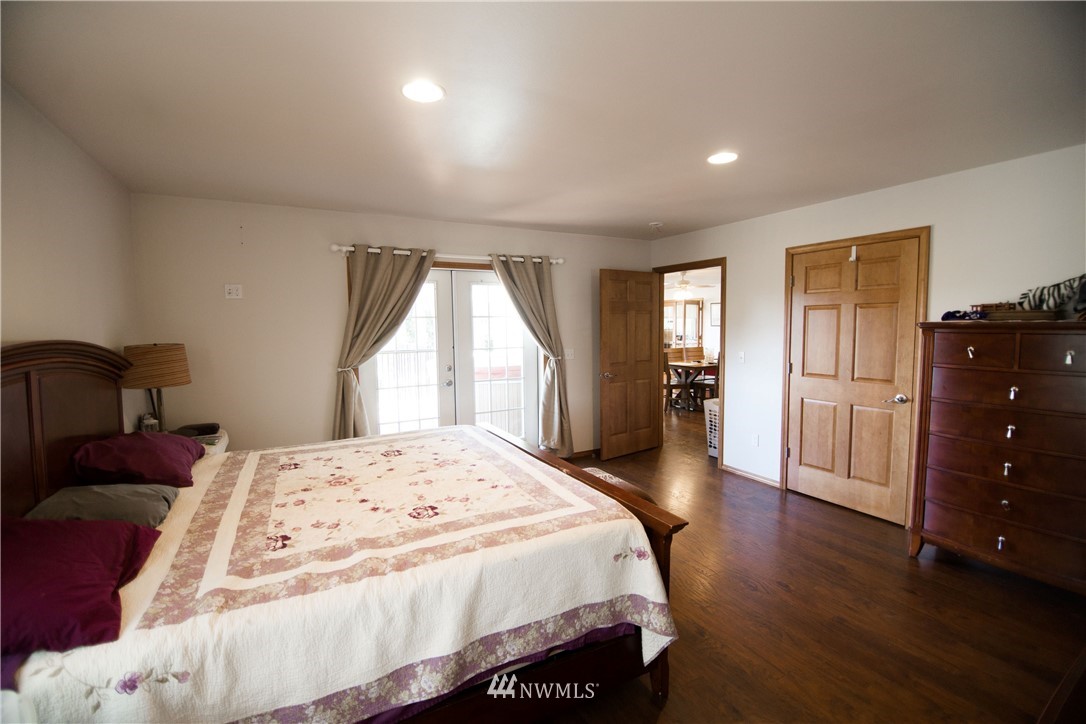 2142 Lincoln Creek Road Rochester, WA 98579 - Photo 22 of 30 a spacious bedroom with a bed and wooden floor