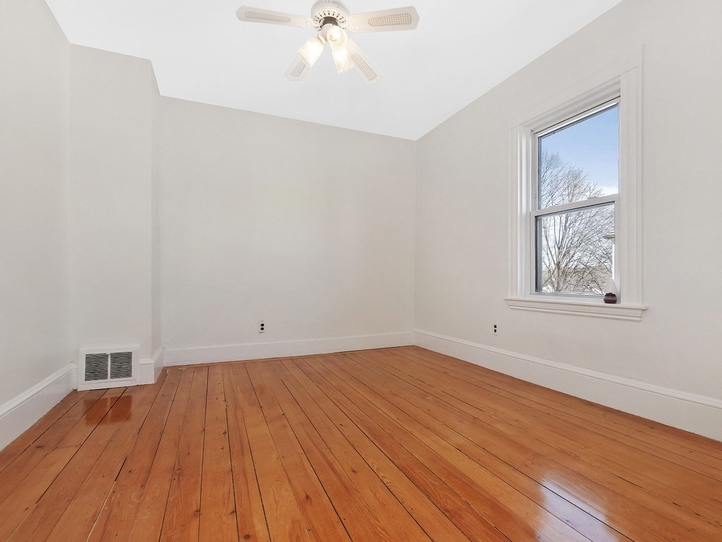 29 Garfield Avenue Boston, MA 02136 - Photo 14 of 27 an empty room with wooden floor and windows