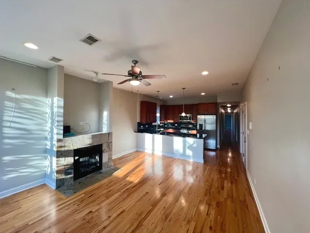 a view of a living room a dining room wooden floor and a fireplace