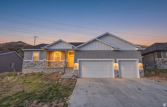 45 Memory Lane Tooele, UT 84074 - Photo 4 of 30 Craftsman-style home with stone siding, a garage, concrete driveway, covered porch, and board and batten siding