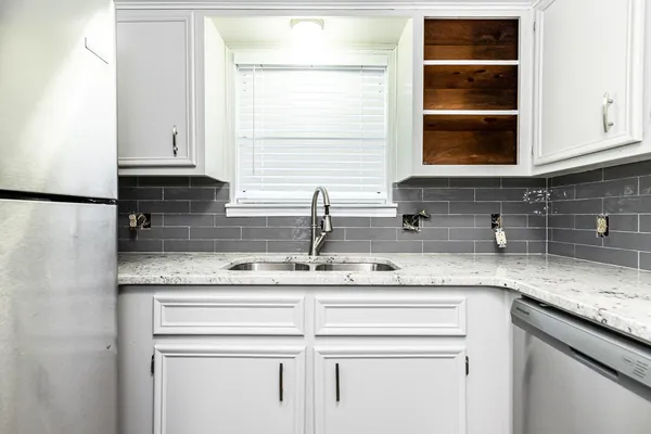 a kitchen with stainless steel appliances granite countertop a sink and a window