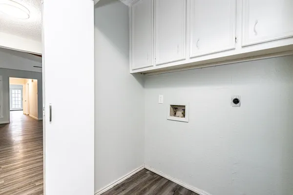 a view of a kitchen with white cabinets and a wooden floor