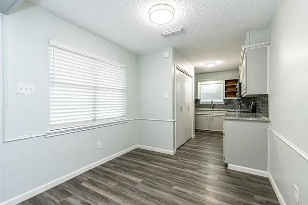 a kitchen with a refrigerator and white cabinets
