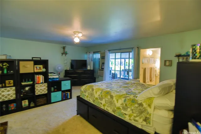 a large bedroom with a bed and a flat screen tv
