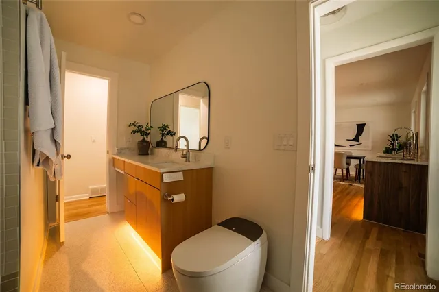 a bathroom with a sink vanity mirror and toilet