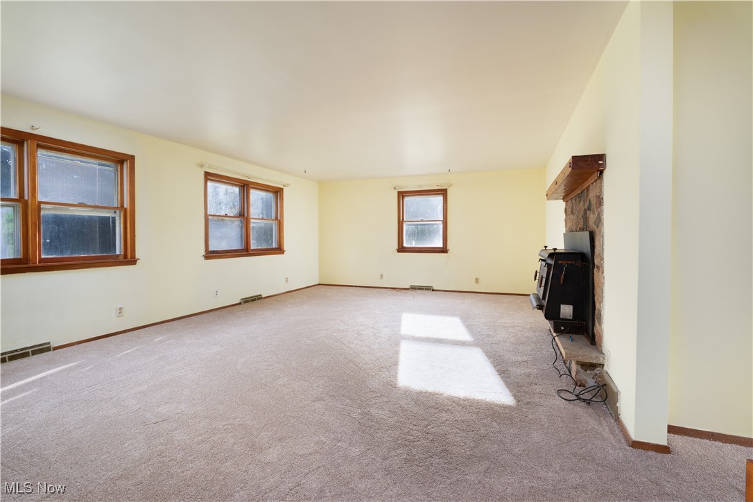 4491 Fox Road Kingsville, OH 44048 - Photo 7 of 33 Unfurnished living room featuring plenty of natural light and light colored carpet