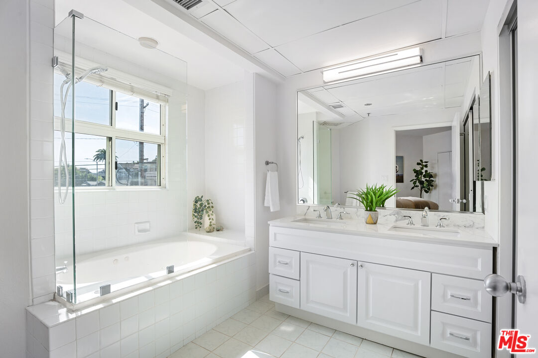 255 Main Street, Unit 101 Venice, CA 90291 - Photo 14 of 28 a spacious bathroom with a granite countertop tub sink a mirror a vanity and shower