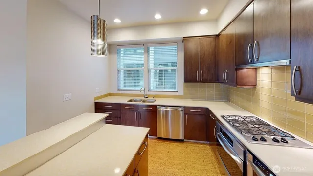 a kitchen with kitchen island granite countertop a sink stove and refrigerator