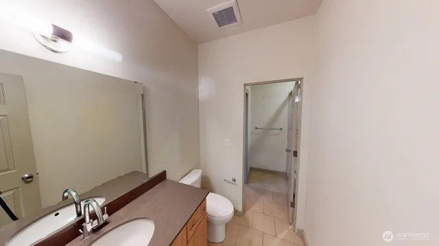 a bathroom with a granite countertop toilet sink and mirror