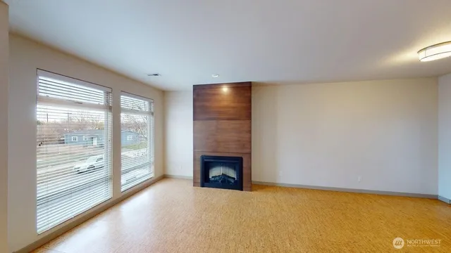 a view of an empty room with a fireplace and a window