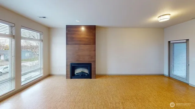 a view of an empty room with a fireplace and a window