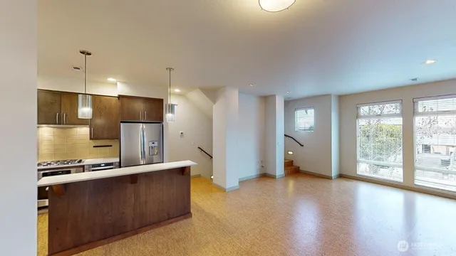 a open kitchen with stainless steel appliances kitchen island wooden floors and large window