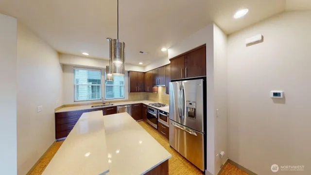 a kitchen with stainless steel appliances a refrigerator and a counter top space