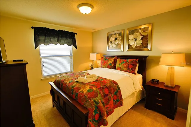 a bed sitting in a bedroom next to a lamp