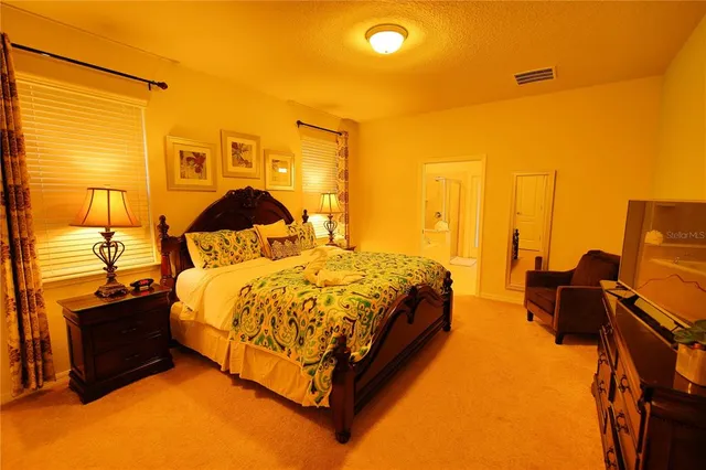 a spacious bedroom with a bed and wooden floor