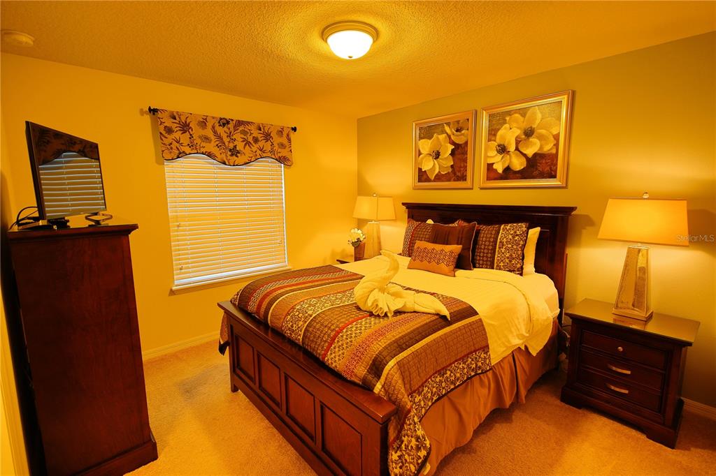 8809 Rhodes Street Kissimmee, FL 34747 - Photo 16 of 49 a bedroom with a bed and wooden floor