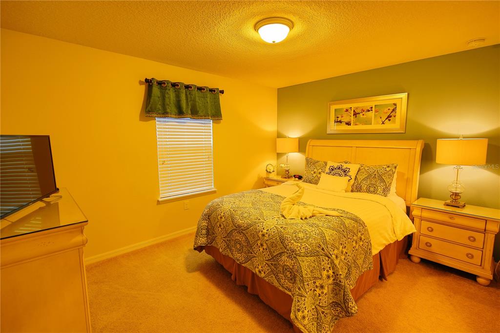 8809 Rhodes Street Kissimmee, FL 34747 - Photo 17 of 49 a bedroom with a bed and lamps