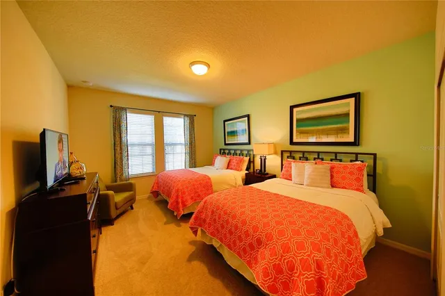 a bedroom with two beds and a flat screen tv