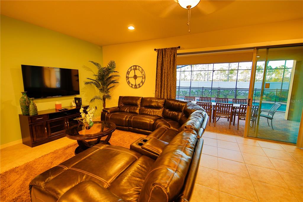 8809 Rhodes Street Kissimmee, FL 34747 - Photo 23 of 49 a living room with patio furniture and a flat screen tv