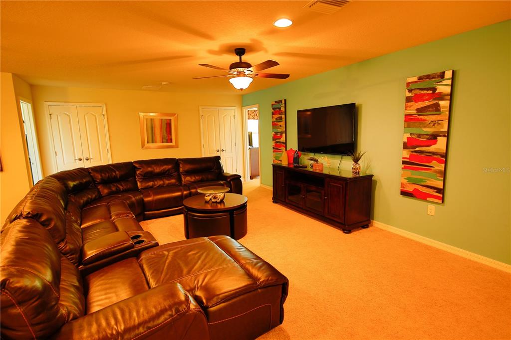 8809 Rhodes Street Kissimmee, FL 34747 - Photo 28 of 49 a living room with furniture and a flat screen tv