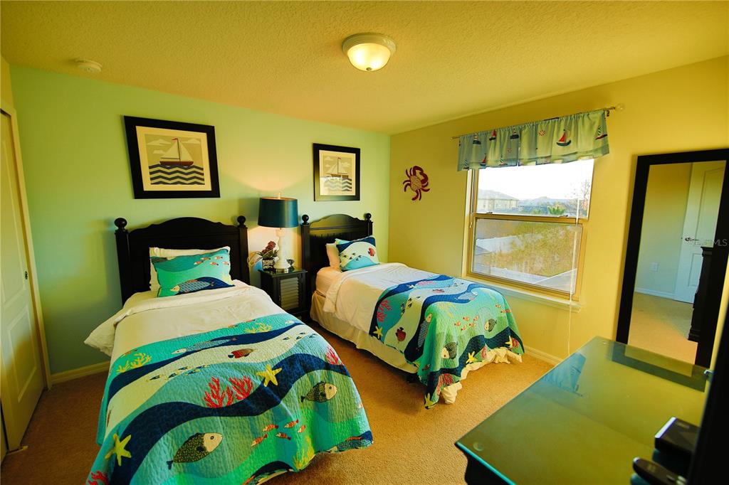 8809 Rhodes Street Kissimmee, FL 34747 - Photo 32 of 49 a bedroom with two beds and painting on the wall