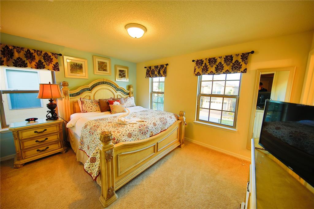 8809 Rhodes Street Kissimmee, FL 34747 - Photo 10 of 49 a spacious bedroom with a bed and wooden floor