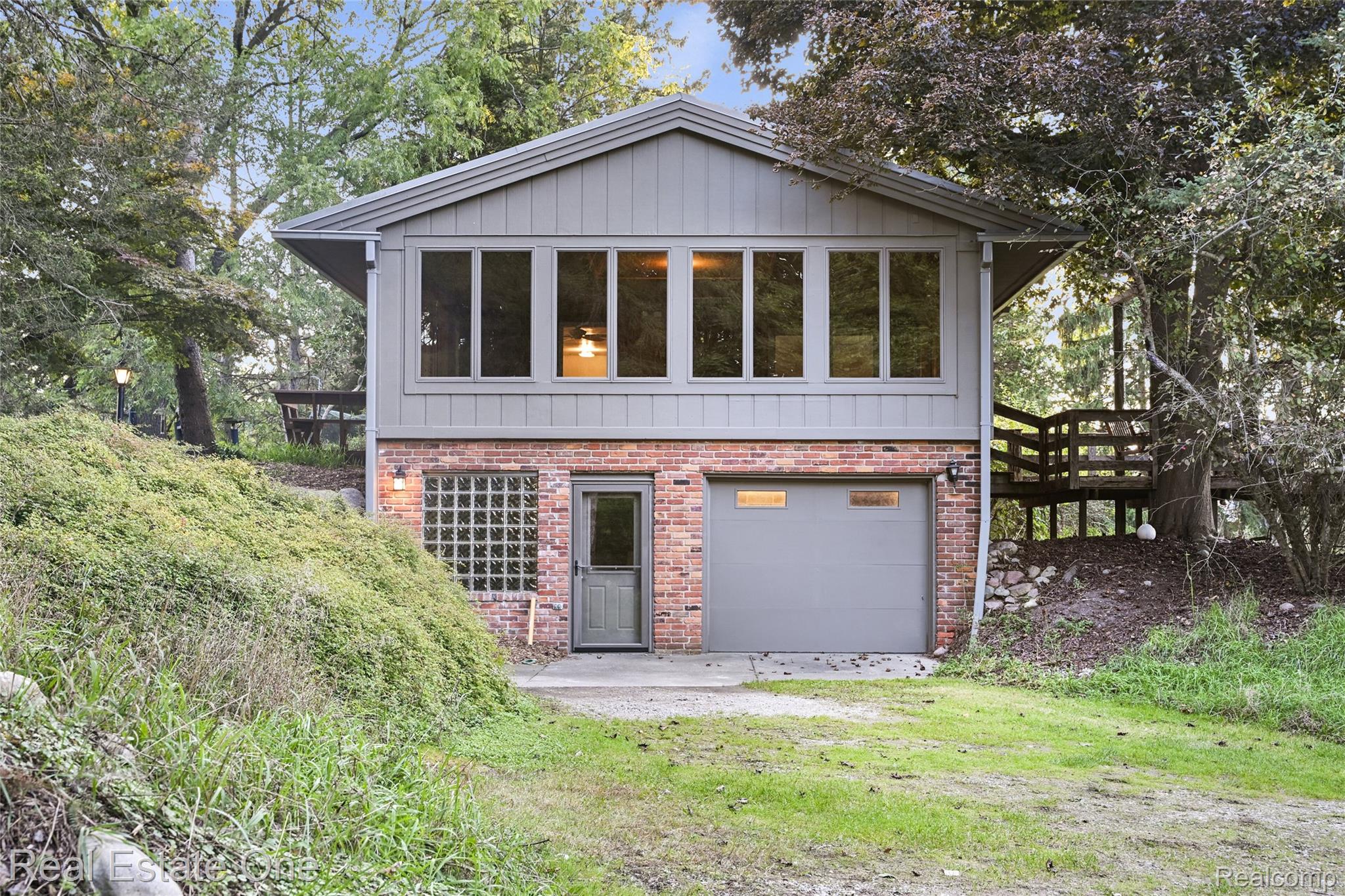 895 Rowe Road Milford, MI 48380 - Photo 2 of 50 Two-story residence featuring brick and horizontal siding, an attached garage, glass block window, and upper-level windows