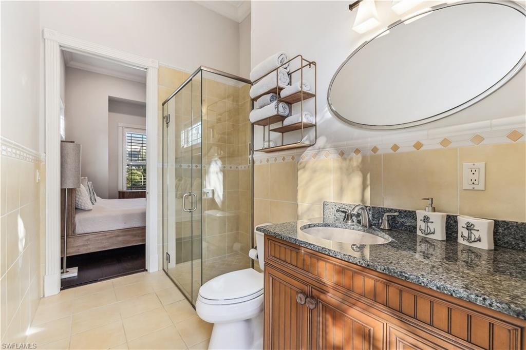 280 Egret Avenue Naples, FL 34108 - Photo 35 of 44 Bathroom with tile patterned flooring, vanity, tile walls, and toilet