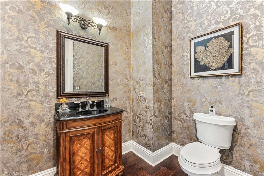 280 Egret Avenue Naples, FL 34108 - Photo 8 of 44 Powder room - featuring wood-type flooring, vanity, and toilet
