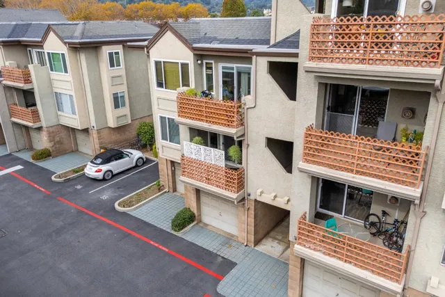 a view of residential houses with outdoor space and parking