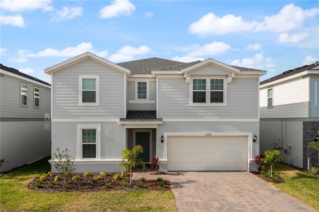 15972 Sandy Cliffs Drive Clermont, FL 34714 - Photo 1 of 85 a front view of a house with a yard and garage