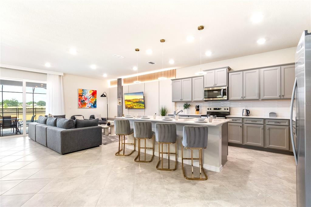 15972 Sandy Cliffs Drive Clermont, FL 34714 - Photo 11 of 85 a living room with stainless steel appliances kitchen island granite countertop furniture and a kitchen view
