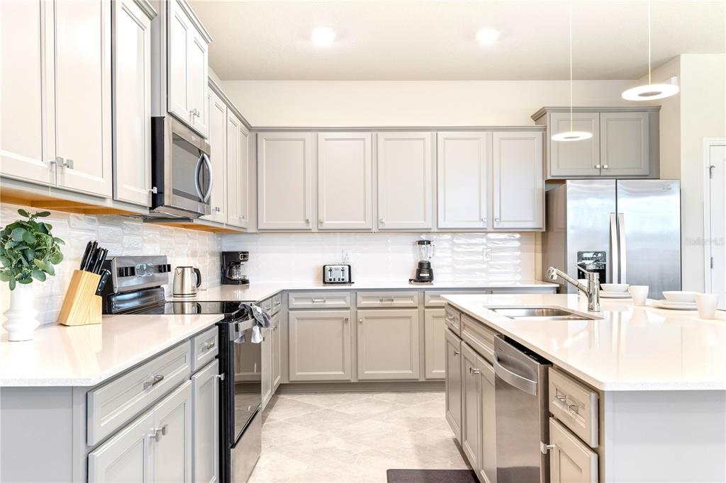 15972 Sandy Cliffs Drive Clermont, FL 34714 - Photo 12 of 85 a kitchen with stainless steel appliances granite countertop a sink a stove and cabinets