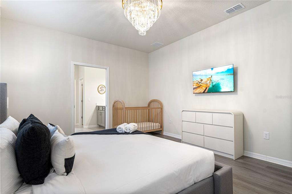 15972 Sandy Cliffs Drive Clermont, FL 34714 - Photo 26 of 85 a bedroom with a bed and a painting on the wall