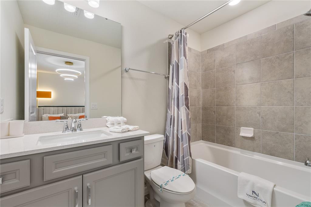 15972 Sandy Cliffs Drive Clermont, FL 34714 - Photo 53 of 85 a bathroom with a sink a toilet a mirror a bathtub and shower