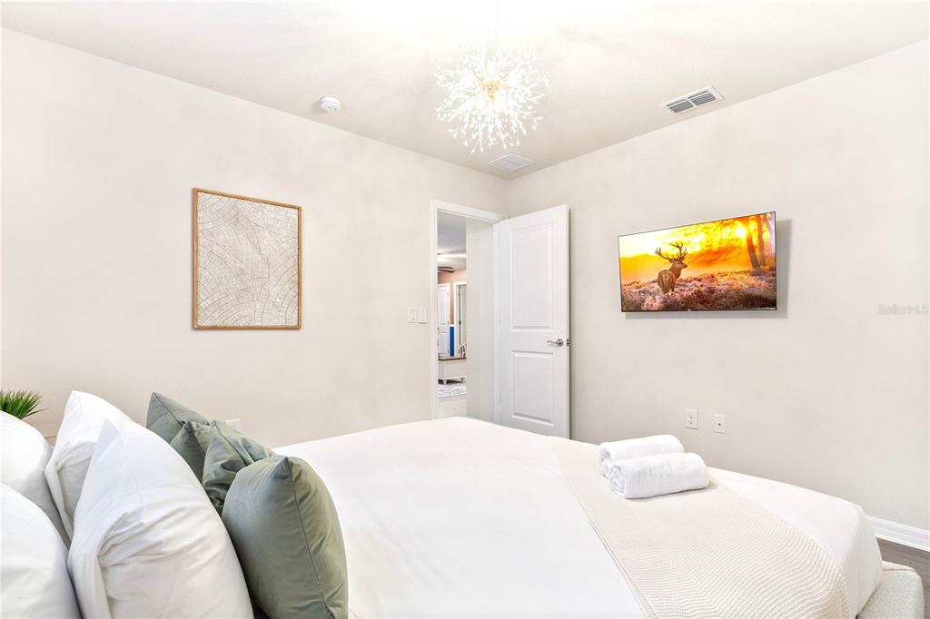 15972 Sandy Cliffs Drive Clermont, FL 34714 - Photo 55 of 85 a bedroom with a bed and a flat screen tv