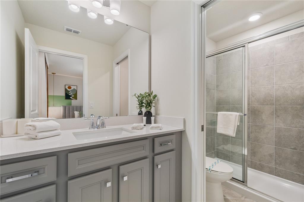 15972 Sandy Cliffs Drive Clermont, FL 34714 - Photo 64 of 85 a bathroom with a granite countertop sink a toilet and shower