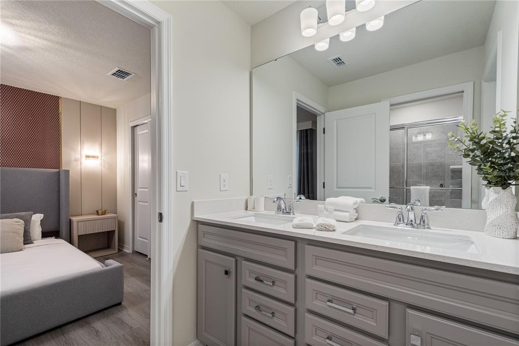 15972 Sandy Cliffs Drive Clermont, FL 34714 - Photo 72 of 85 a bathroom with a double vanity sink and a mirror