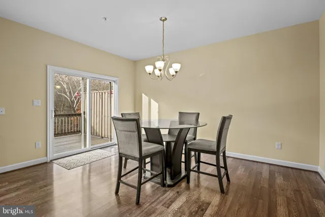 a dining room with furniture a chandelier and wooden floor