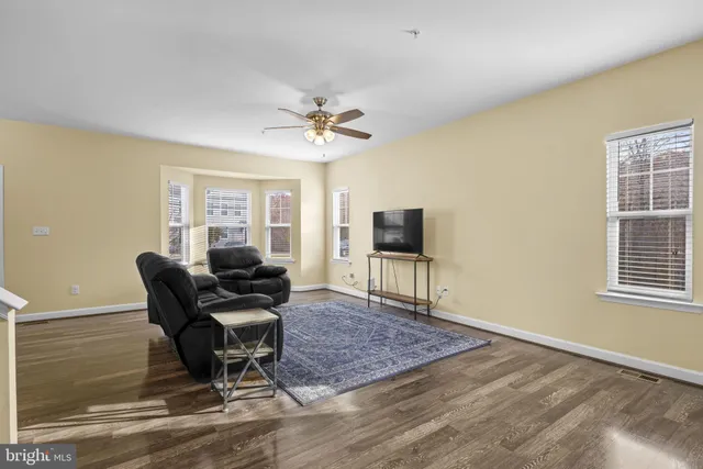 a living room with furniture a flat screen tv and a window