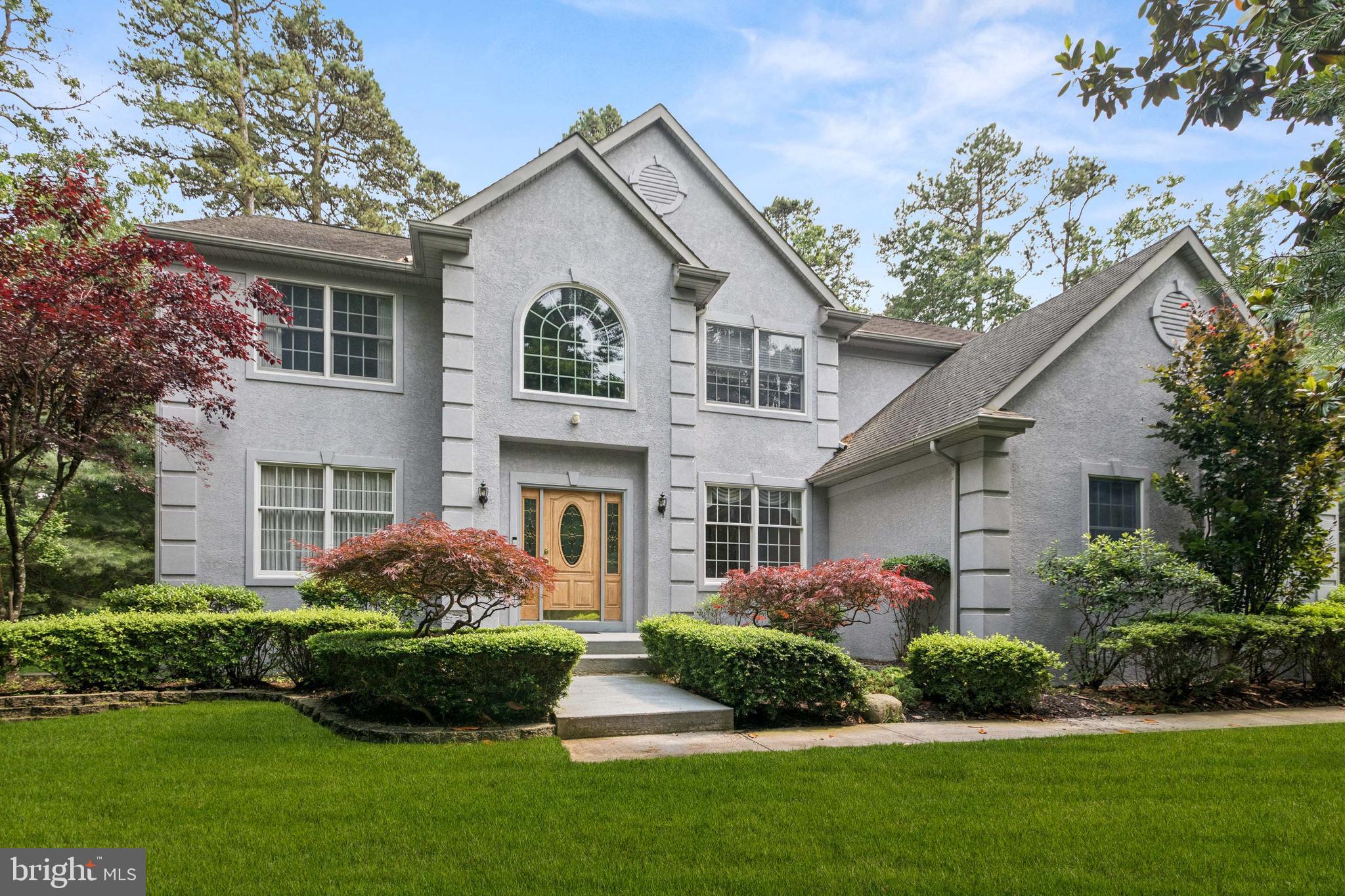 a front view of a house with a garden and plants