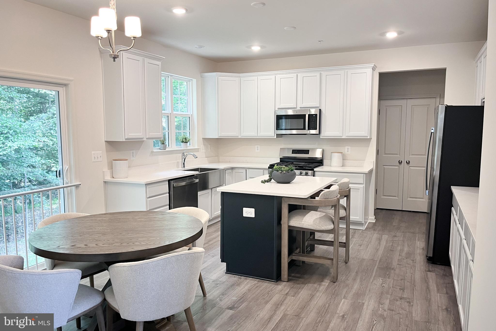 1326 Heaps Road Whiteford, MD 21160 - Photo 6 of 19 a kitchen with stainless steel appliances granite countertop a dining table chairs refrigerator sink and cabinets