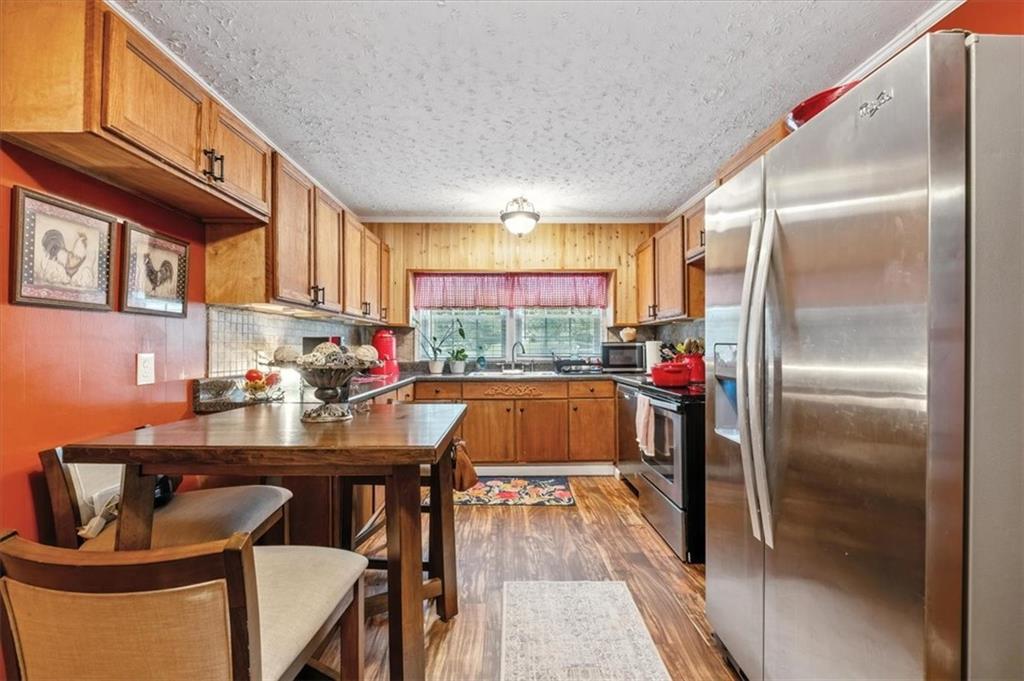 241 River Bend Road Southwest Plainville, GA 30733 - Photo 13 of 27 a kitchen with kitchen island a large window and refrigerator