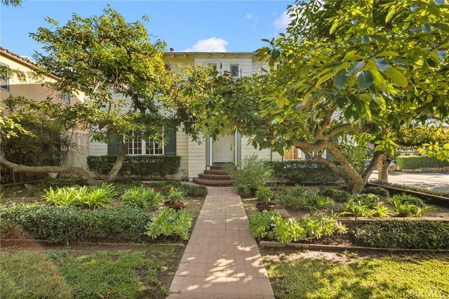 a front view of a house with a yard and fountain