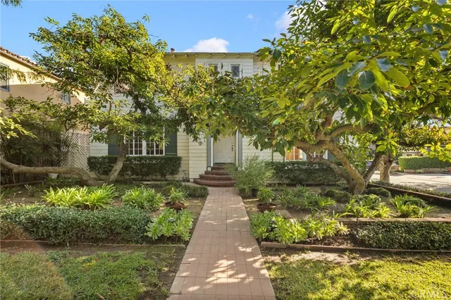 a front view of a house with a yard and fountain