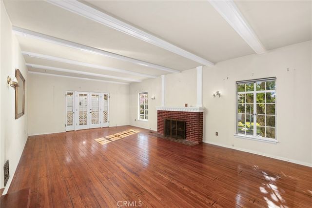 a view of empty room with wooden floor and fireplace