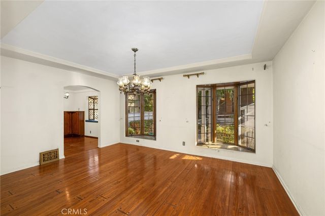 a view of an empty room with window and wooden floor
