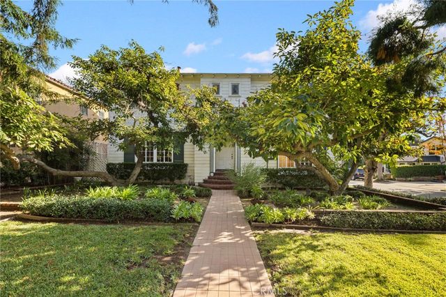 a front view of a house with a yard and trees