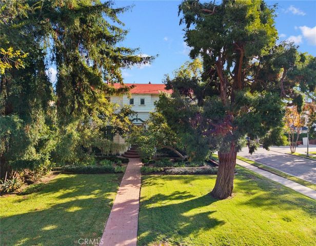a view of a swimming pool with a yard and large trees