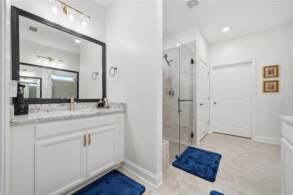 707 Evergreen Lane Canton, GA 30114 - Photo 23 of 59 a spacious bathroom with a granite countertop sink mirror and shower